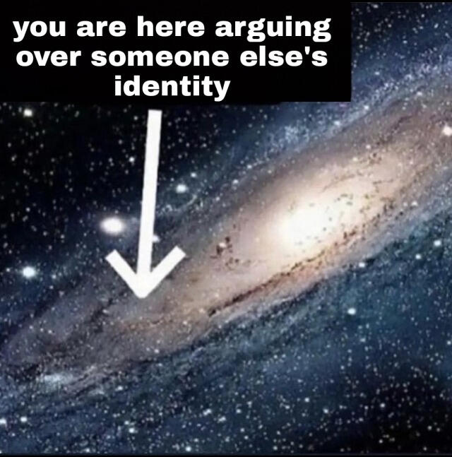 Image ID: A realistic artistic rendering of the Milky Way galaxy. Superimposed onto it is a white arrow, pointed approximately at our solar system, with white text on a black background that reads "You are here arguing over someone else's identity. End ID.
